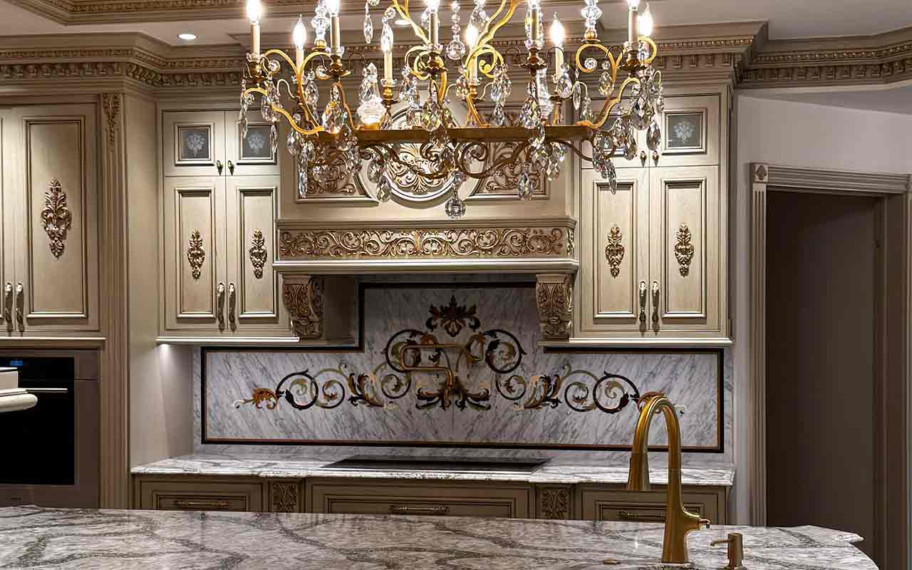 Luxury kitchen with a custom marble backsplash inlay featuring ornate floral scrollwork. Handcrafted decorative stone wall art for high-end kitchen design by Czar Floors.