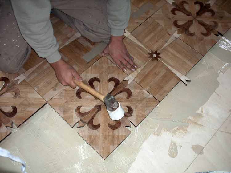 Tapping parquet tiles to insure  adhesion
